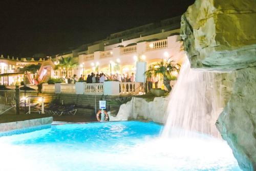 卡尔佩Imperial park resort的夜间在度假村游泳池的瀑布