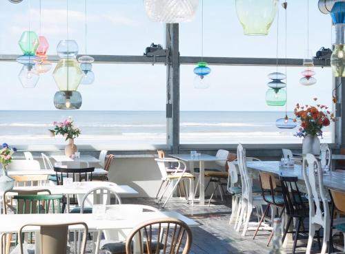 滨海贝亨Villa de Duinfazant的一间带桌椅的海景餐厅