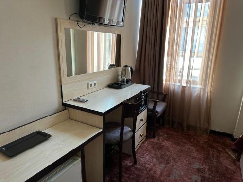 第比利斯Hotel Europe plaza的酒店客房配有书桌和镜子
