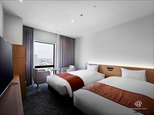 埼玉市Daiwa Roynet Hotel Omiya-nishiguchi的酒店客房设有两张床和窗户。
