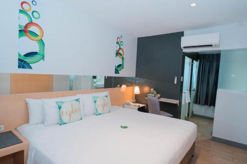 IliganGo Hotels Iligan的卧室配有带枕头的大型白色床