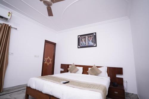 新德里Hotel Lecston @Yashobhoomi Dwarka Sector - 25 metro station的一间白色客房内的床铺卧室