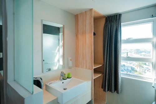 IliganGo Hotels Iligan的一间带水槽和镜子的浴室以及窗户。