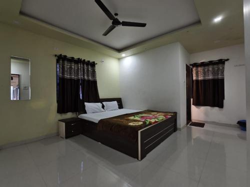马哈巴莱斯赫瓦尔Shayadri Farmhouse的一间卧室配有一张床和吊扇
