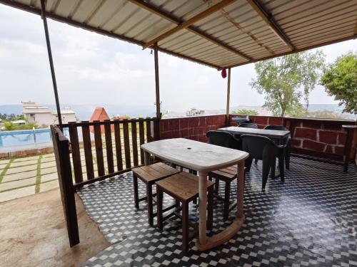 马哈巴莱斯赫瓦尔Shayadri Farmhouse的美景庭院内的桌椅