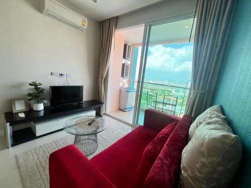 南芭堤雅Grande Cariibbean Pattaya by Thita的客厅设有红色的沙发和大窗户