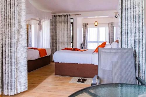 奈瓦沙Naivasha Wonderland Resort的酒店客房,设有两张床和一张玻璃桌