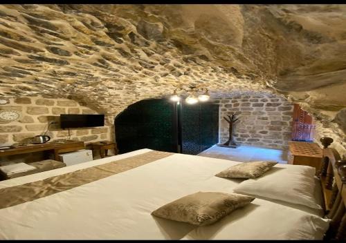 马尔丁Old City Tourism的卧室配有一张石墙内的大床