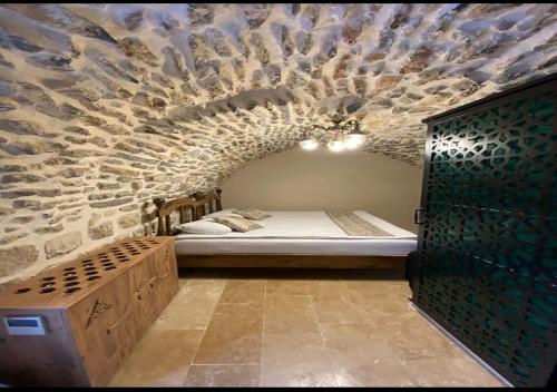 马尔丁Old City Tourism的卧室配有一张石墙床