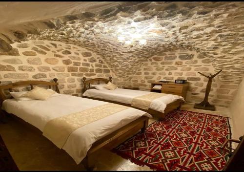 马尔丁Old City Tourism的石墙客房的两张床