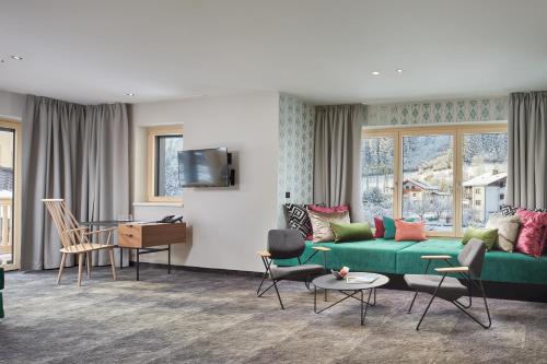 迈尔霍芬胡贝尔精品酒店的客厅配有绿色沙发和椅子