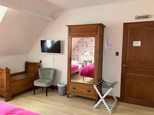 谢尔河畔努瓦耶La Noisetiere的一间卧室配有镜子、一张床和一把椅子