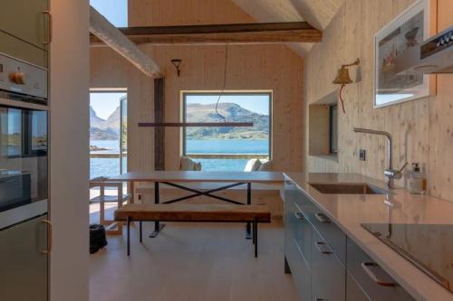 拉姆贝格Minkfarmen, Spacious seaside cabin with scenic view的厨房配有桌子和长凳