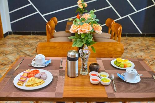 TurianiLa Vista Garden Hotel的一张桌子,上面放着食物和花瓶