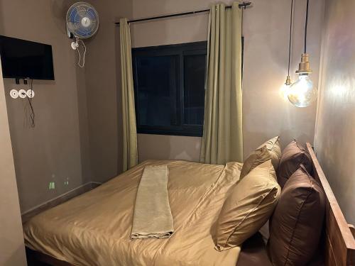 塔那那利佛NH (Njato Hôtel)的卧室内的一张带枕头的床和一扇窗户