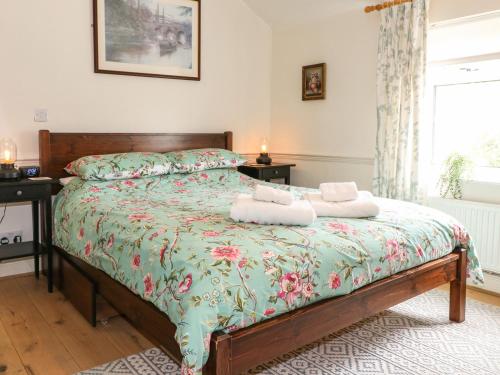 拉夫堡Periwinkle Cottage的一间卧室配有一张床,上面有两条毛巾