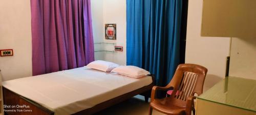 特里凡得琅Parthasarathy的小房间,配有床和色彩缤纷的窗帘