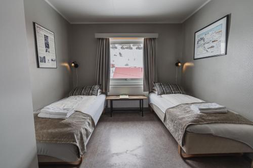 朗伊尔城煤矿工小屋旅舍的带窗户的客房内的两张床