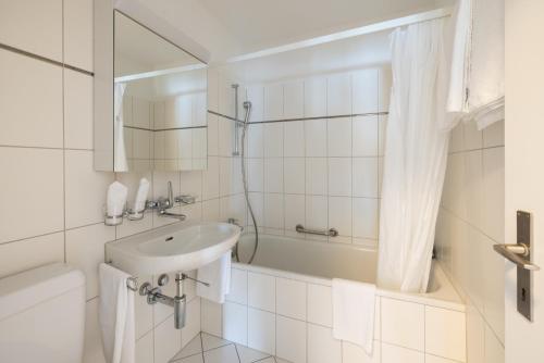 苏黎世EMA House Serviced Apartments Aussersihl的白色的浴室设有水槽和浴缸。