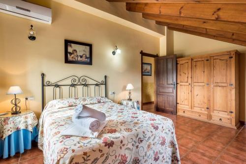 Almogía5 bedrooms villa with private pool and wifi at Almogia的一间带一张床的卧室,位于带木制天花板的房间内