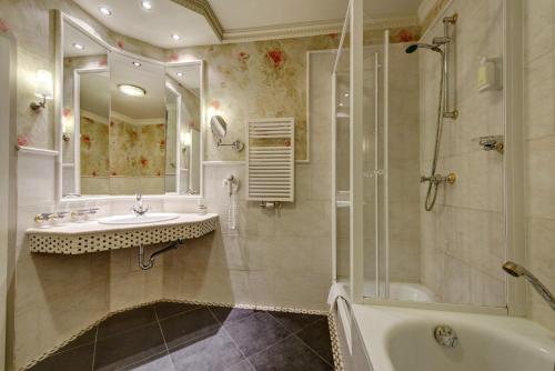 奥斯赛拜-屈隆斯博恩Strandhotel Nordischer Hof的带浴缸、水槽和淋浴的浴室