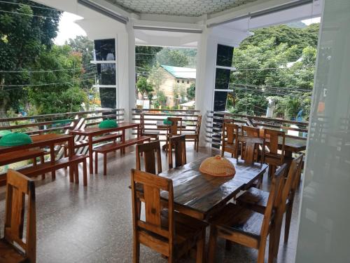 Guinisilibanbucana traveler's inn的客房设有木桌、椅子和大窗户。