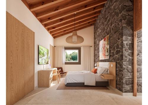 Antas de UllaReverence Villas Caldelas的一间卧室设有一张床和石墙