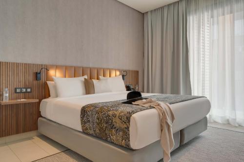 卡萨布兰卡佩斯塔纳卡萨布兰卡，海滨套房及公寓酒店的一间卧室配有一张大床,猫坐在床上