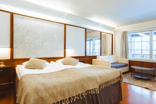 鲁卡皇家卢卡酒店的一间卧室配有一张床、一把椅子和窗户。