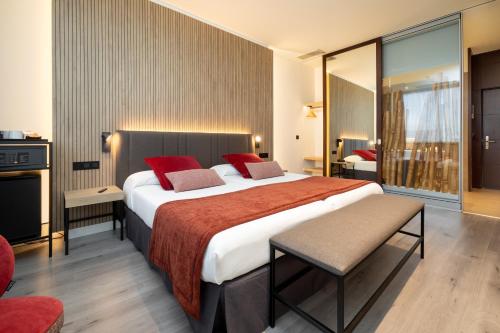 略夫雷加特河畔奥斯皮塔莱特Alexandre Fira Congress的酒店客房配有一张带红色枕头的大床