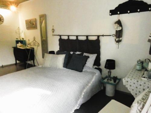 弗罗夏佩勒Chambre poésie的一间卧室配有一张白色的床和黑色床头板