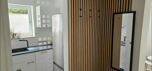 卡尔夫Ferienwohnung Auszeit的厨房配有白色橱柜、水槽和窗户。
