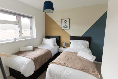 斯塔福德Perfect for Contractors & Families + Free Parking + Wifi的一间卧室设有两张床和窗户。