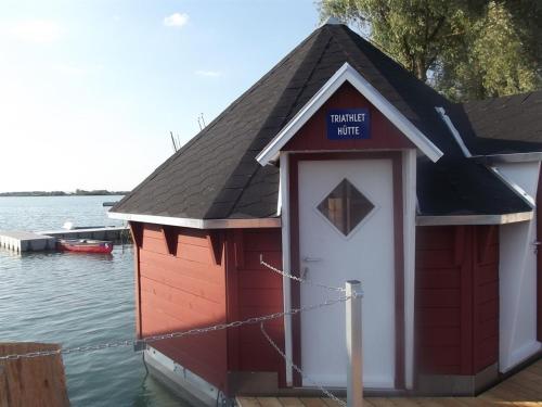 StotternheimMaritime Freizeit Camp "MFC" Erfurter Seen的水面上的红白船屋