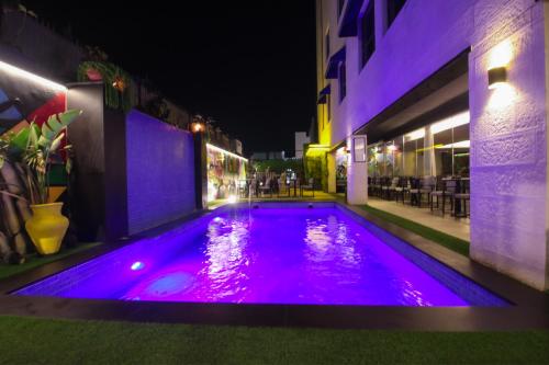 安曼Monarch Hotel Amman的一座建筑中一座带紫色灯光的游泳池
