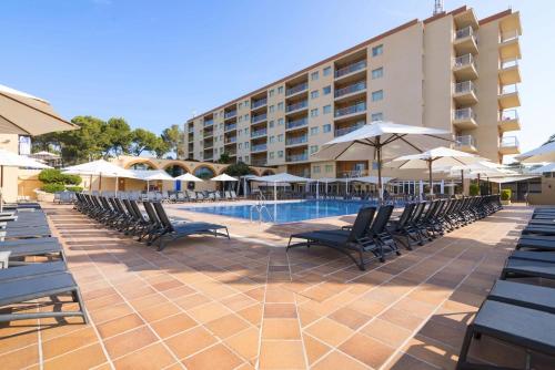 埃斯卡纳Hotel Atlantic by Hoteles Centric的酒店旁的游泳池配有椅子和遮阳伞