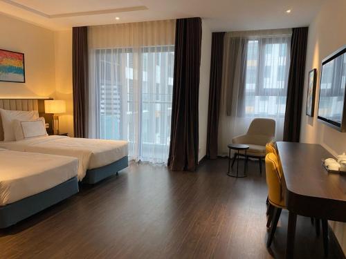 下龙湾The Sapphire Ha Long的酒店客房设有一张床、一张书桌和窗户。