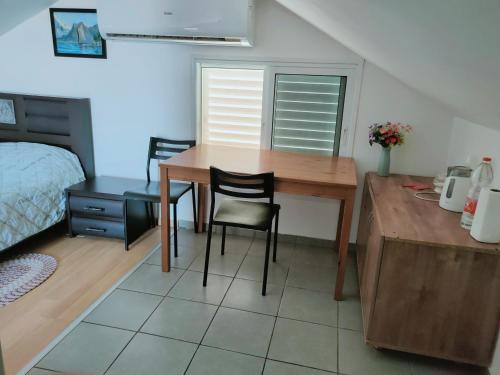埃拉特Guest House VeryMary Eilat Stydio的配有桌子和两把椅子及一张床的房间