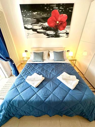 里米尼Giardino al mare的卧室配有蓝色的床,墙上挂着红花