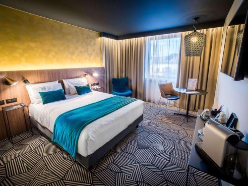阿拉斯水星阿特里亚阿拉中央酒店的酒店客房设有一张大床和一张书桌。