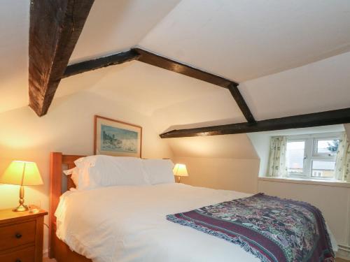 比明斯特Poppy Cottage的卧室配有白色的床和窗户。