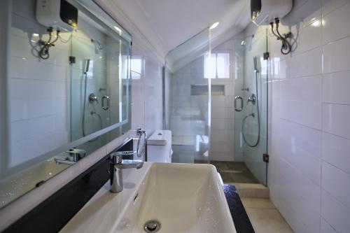 阿布贾Hamasville Boutique Hotel的一间带水槽、镜子和卫生间的浴室