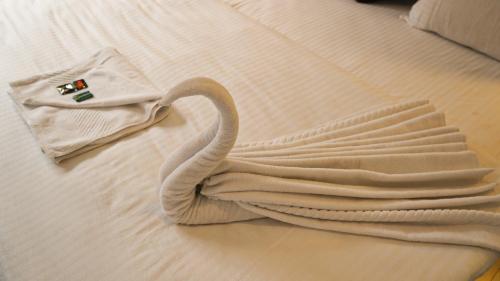 甘托克Hotel Sherabling的天鹅躺在床上,带毛巾