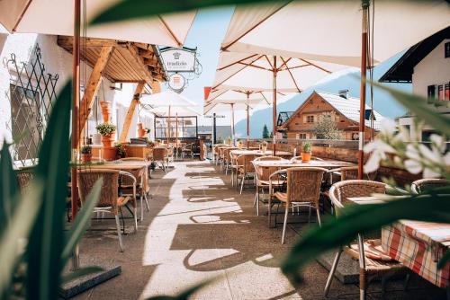米特尔贝格Hotel Tradizio的一间带桌椅和遮阳伞的餐厅