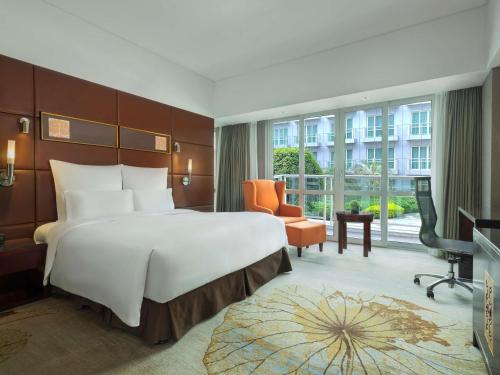 广州Pullman Guangzhou Baiyun Airport的酒店客房设有一张大床和一张书桌。