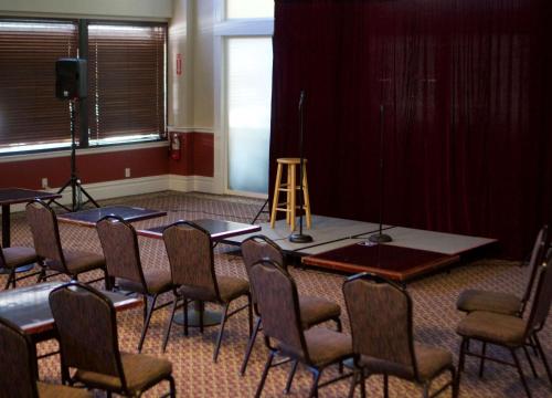 奥克兰华盛顿旅馆的配有桌椅和舞台的房间