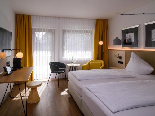 巴特塞森多夫Hotel Schnitterhof的酒店客房带一张床、一张桌子和椅子