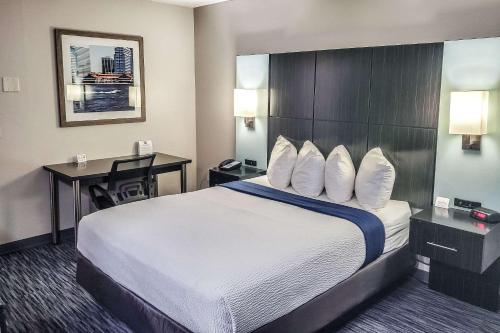 橘园Quality Inn Southside Jacksonville的酒店客房设有一张大床和一张书桌。