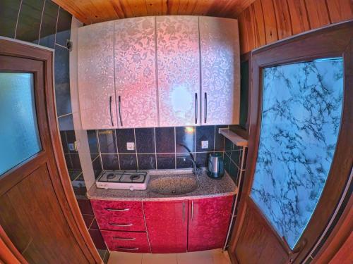 乌宗UZUNGÖL ADİLOGLU SUIT的一个带水槽和两个窗户的小厨房