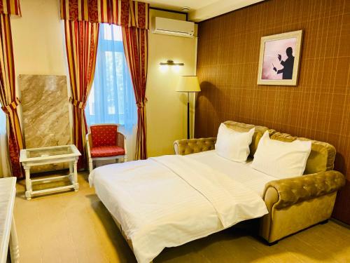 锡比乌Villa & Restaurant Levoslav House的配有一张床和一把椅子的酒店客房